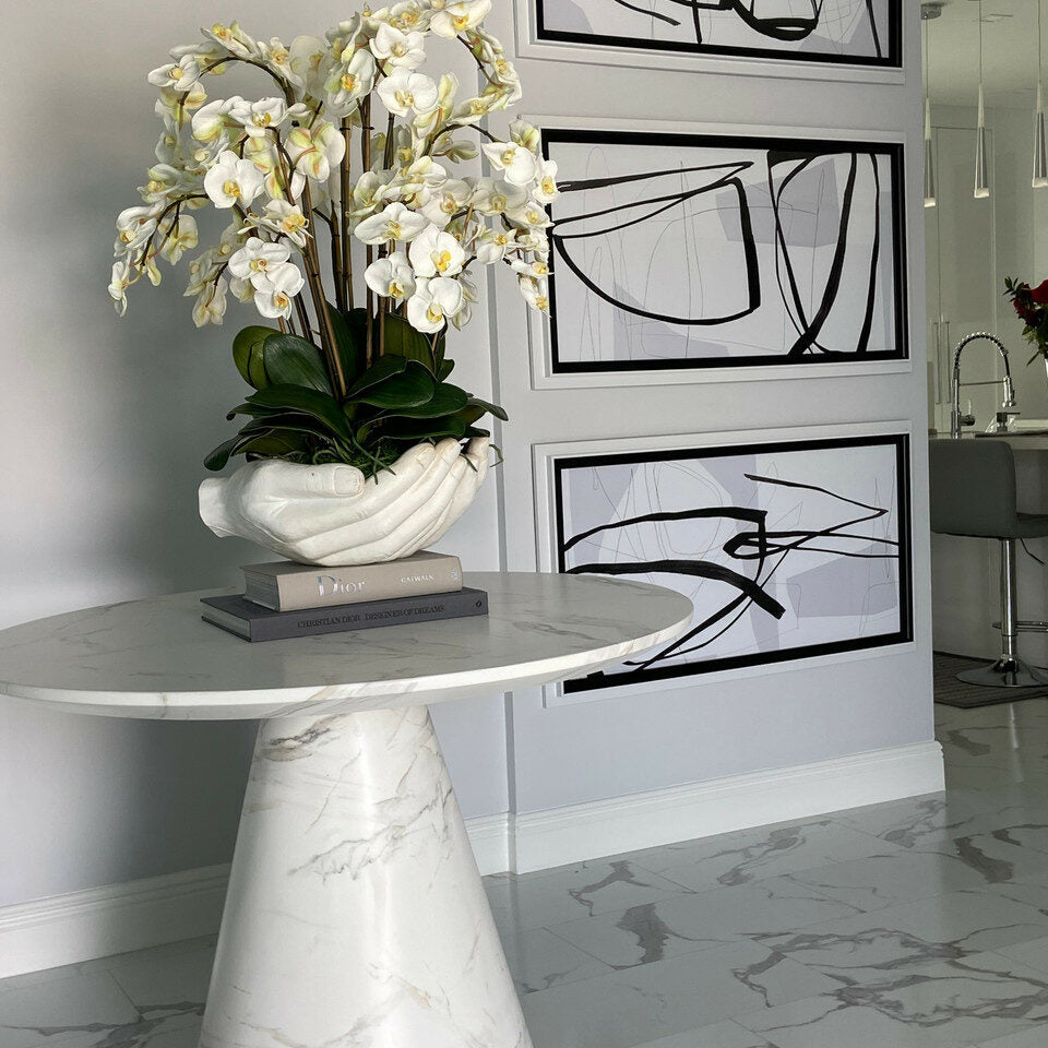 Orchidées Phalaenopsis blanches dans un vase sculpture de mains ouvertes