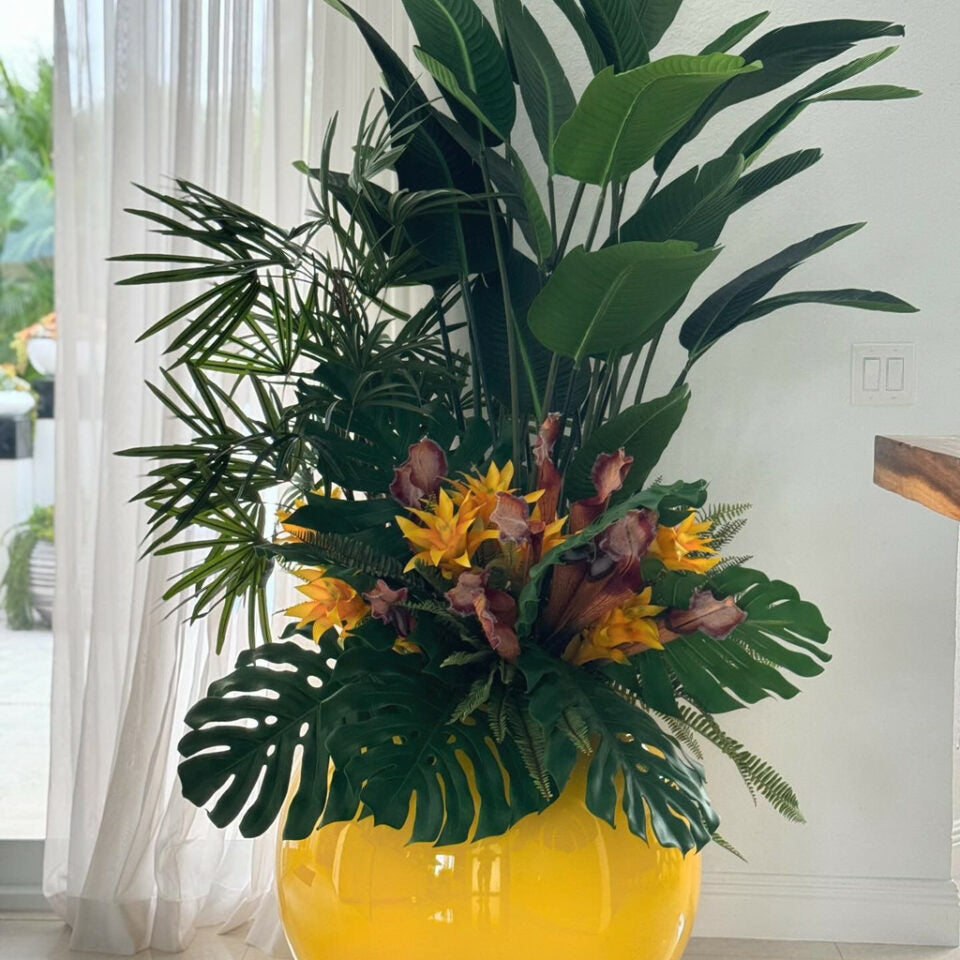 Mix de plantes tropicales dans un vase globe jaune