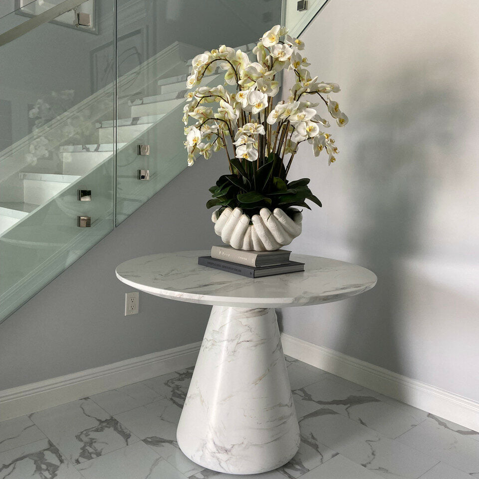 Orchidées Phalaenopsis blanches dans un vase sculpture de mains ouvertes