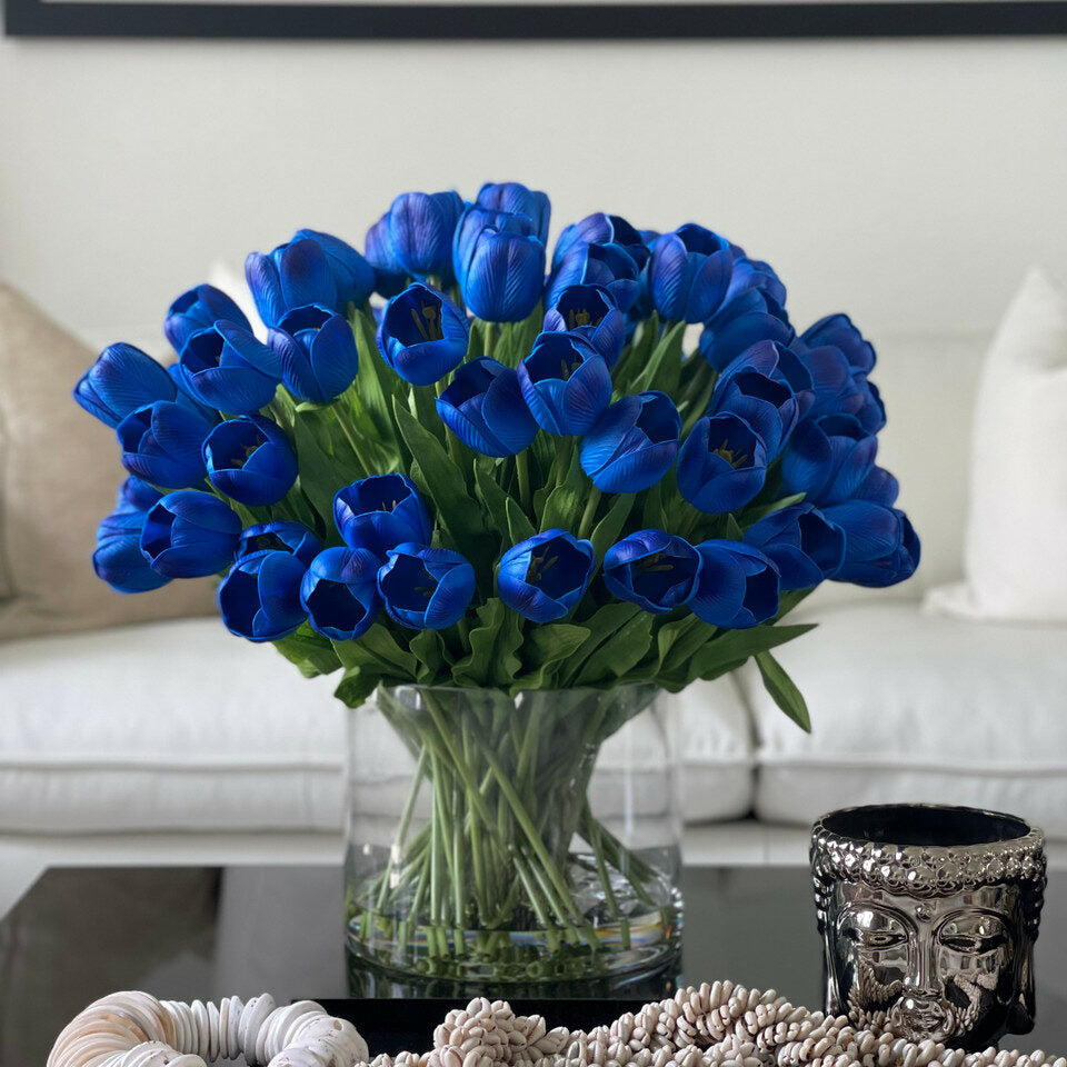 Arrangement de tulipes bleues dans un grand vase cylindrique