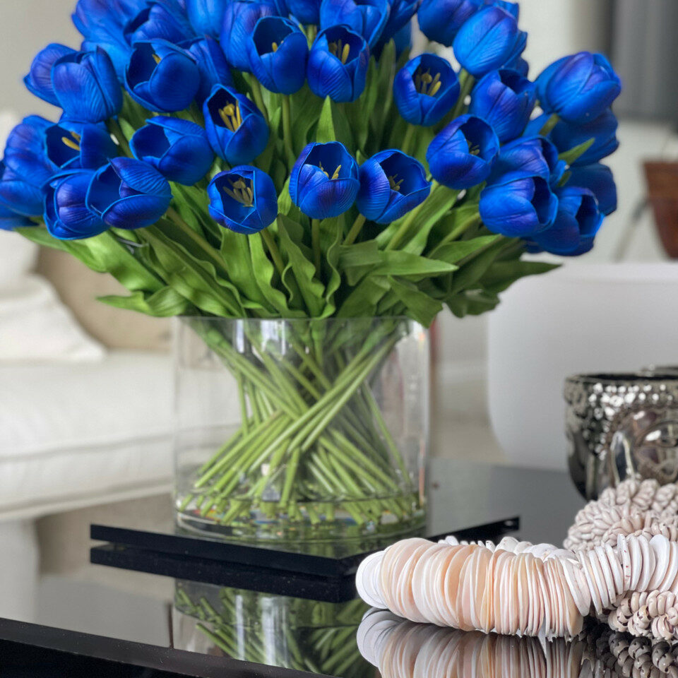 Arrangement de tulipes bleues dans un grand vase cylindrique