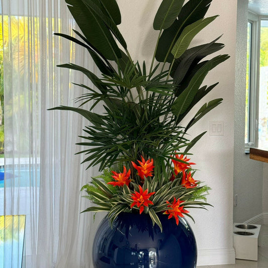 Mix de plantes tropicales dans un vase globe bleu cobalt